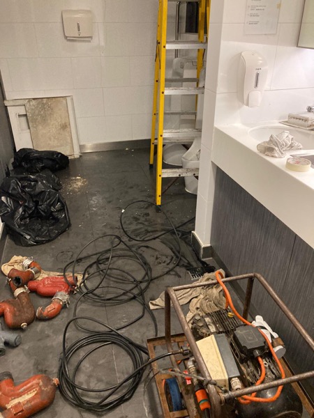 DrainFix HK 商業樓宇廁所現場,紅色鑄鐵 P-trap、電動通渠機、垃圾袋擺好預備工作