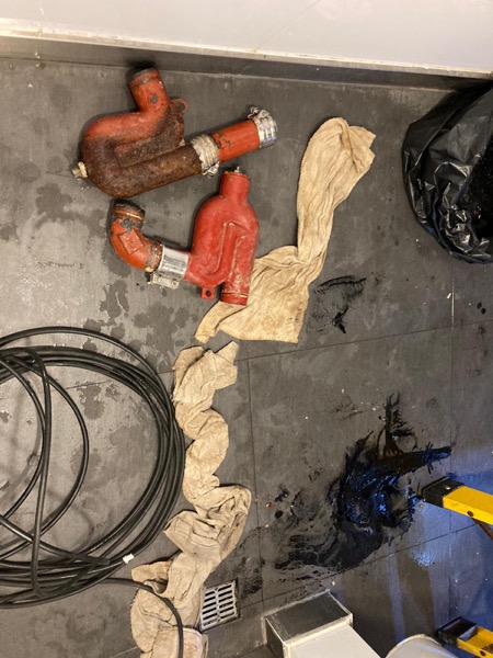 DrainFix HK 同一單拆出嘅多段紅鑄鐵渠管擺在客戶廚房地下,連 stainless coupling